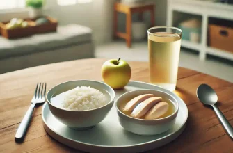 Light and healthy meal for colonoscopy preparation with clear broth, white rice, boiled chicken, and apple juice on a wooden table in a clean kitchen setting.