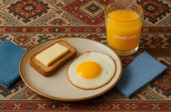 School breakfast with fried egg, bread with butter and cheese, and orange juice.