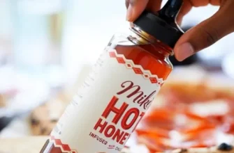 Bottle of Mike’s Hot Honey held over food — article explores its health benefits, risks, and safe use.